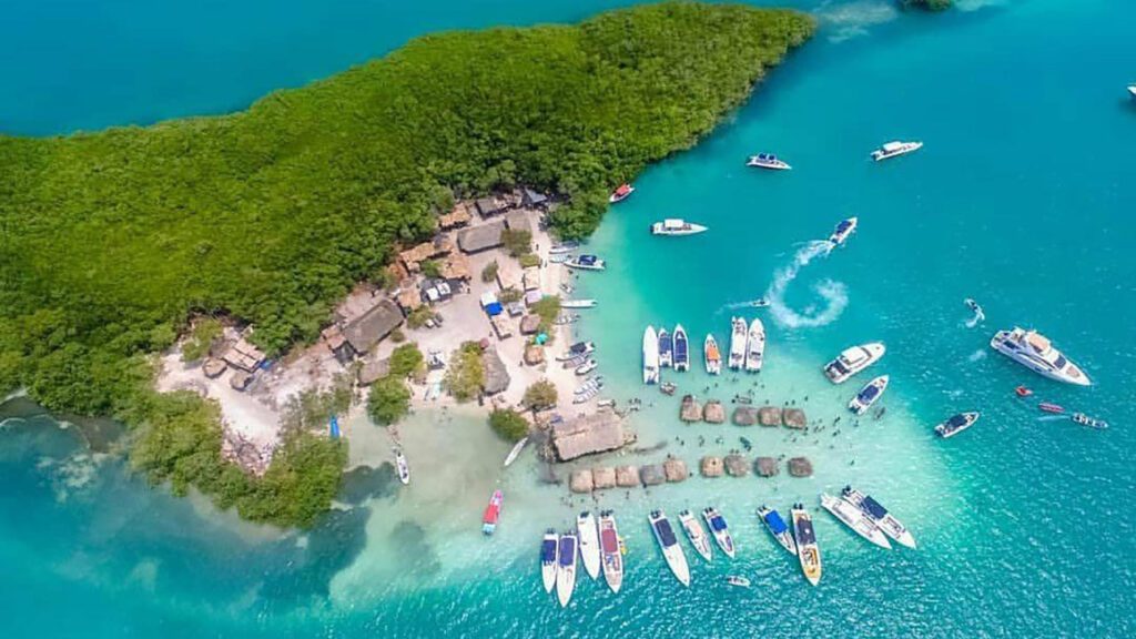 Botes de fiesta anclados en el agua turquesa de Isla Cholón, vista aérea