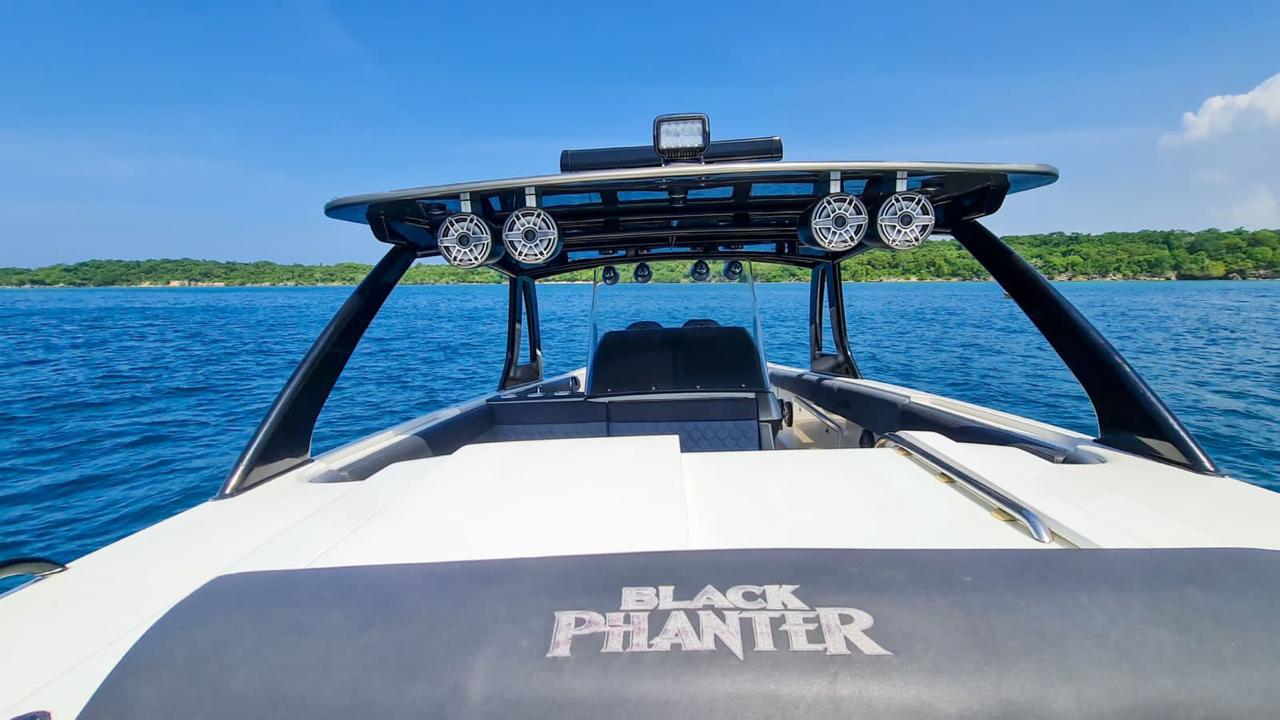 Tourists boarding a mini fast yacht with four motors.