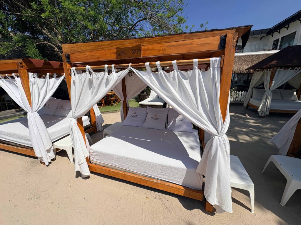 Cama balinesa con cortinas blancas en un beach club cerca de Barú