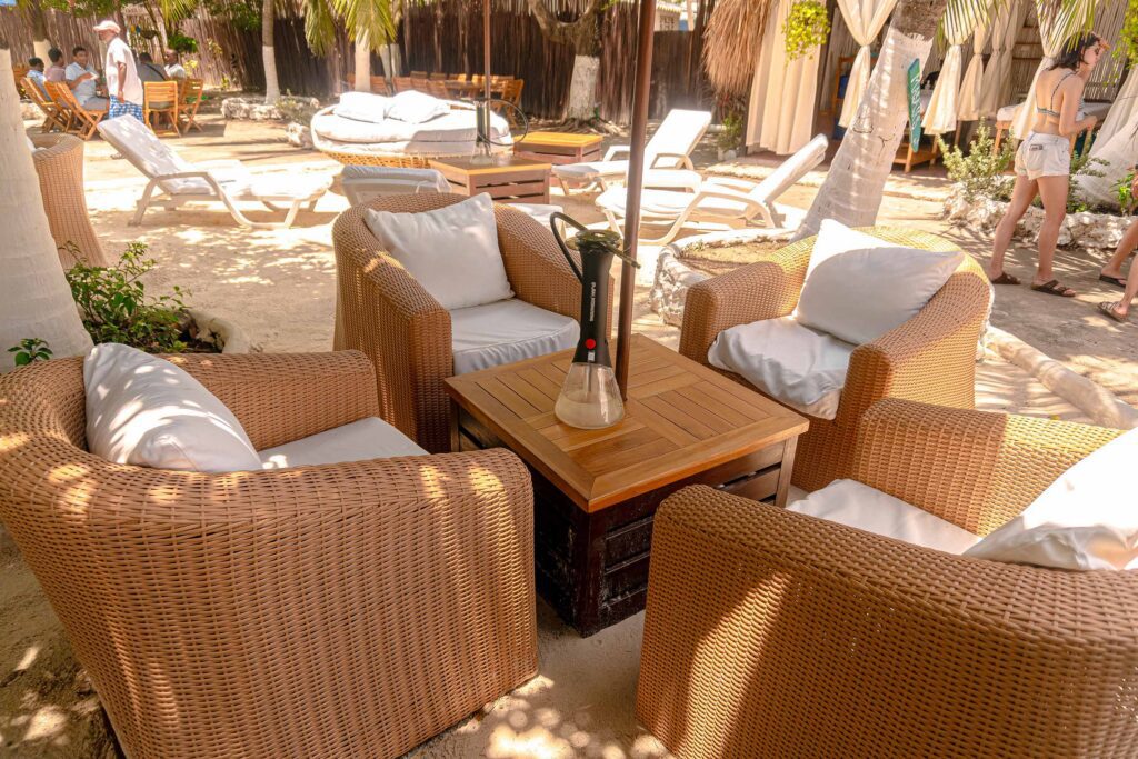 Zona lounge con muebles de mimbre en un beach club de las islas de Cartagena