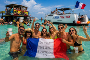 Touristes français faisant la fête dans l’eau turquoise de Cholón à Cartagena avec drapeau français, bateaux et ambiance caribéenne